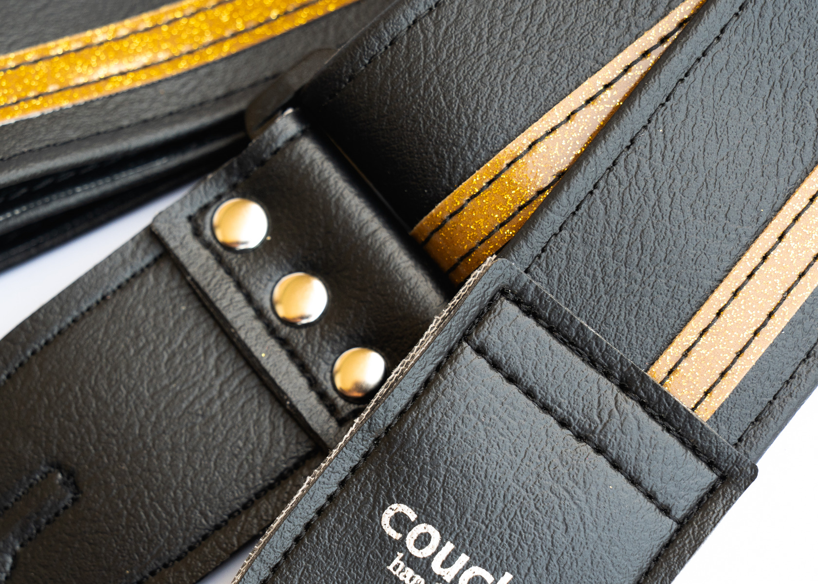 Close-up of the back tab with three hand-tooled gold-toned rivets