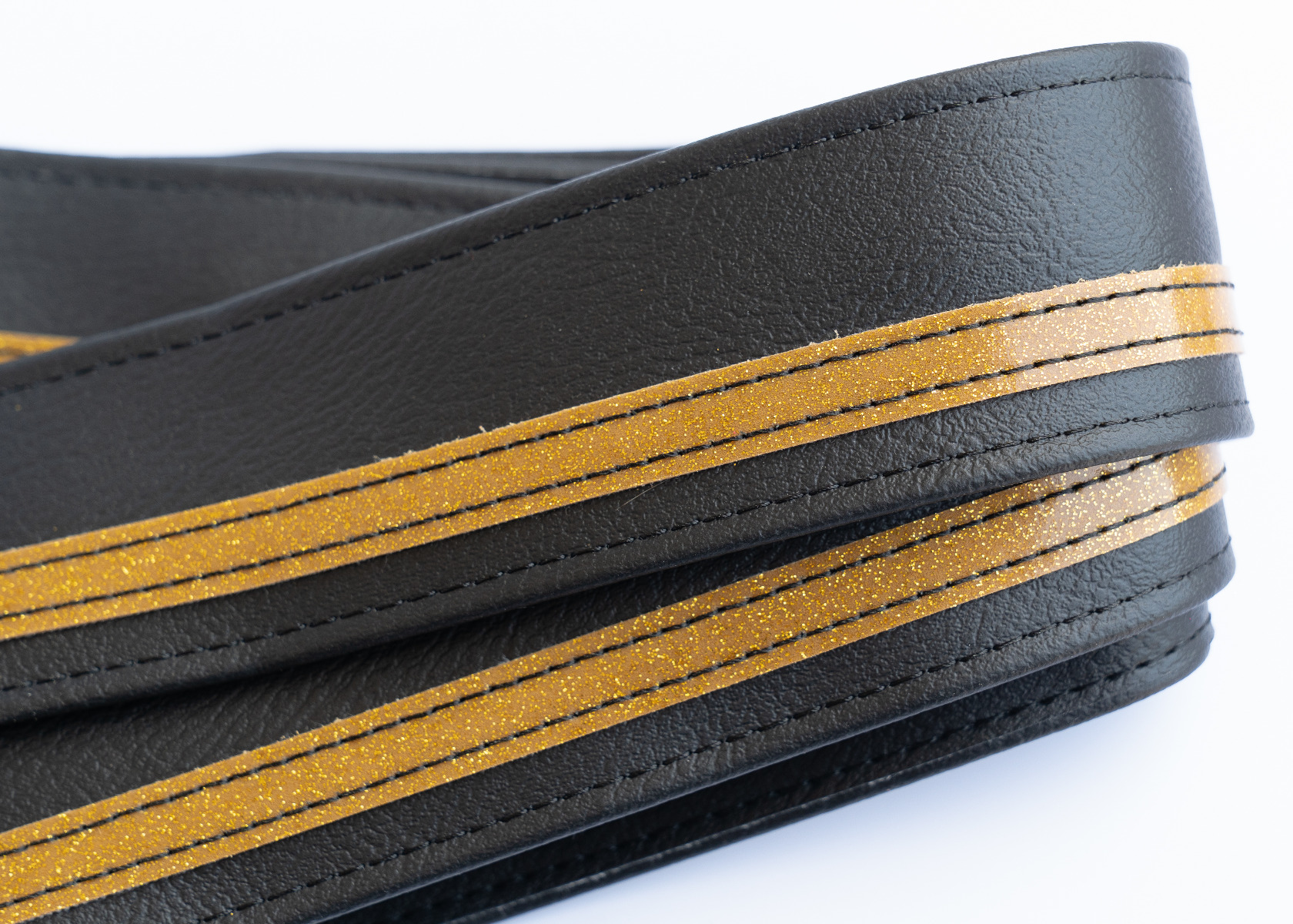 Close-up of the offset gold racing stripe on the black vinyl strap