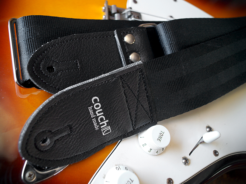Close-up of the Couch logo tab, rivets and keyhole on a sunburst guitar