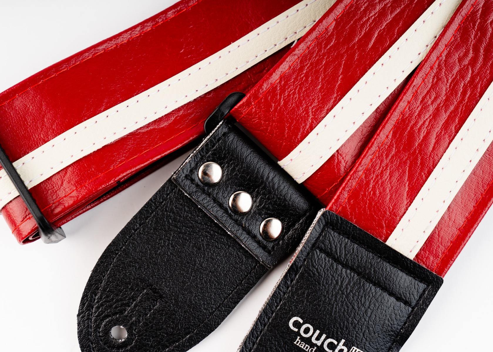 Black vinyl end tabs with three nickel rivets on the Red Racer-X strap