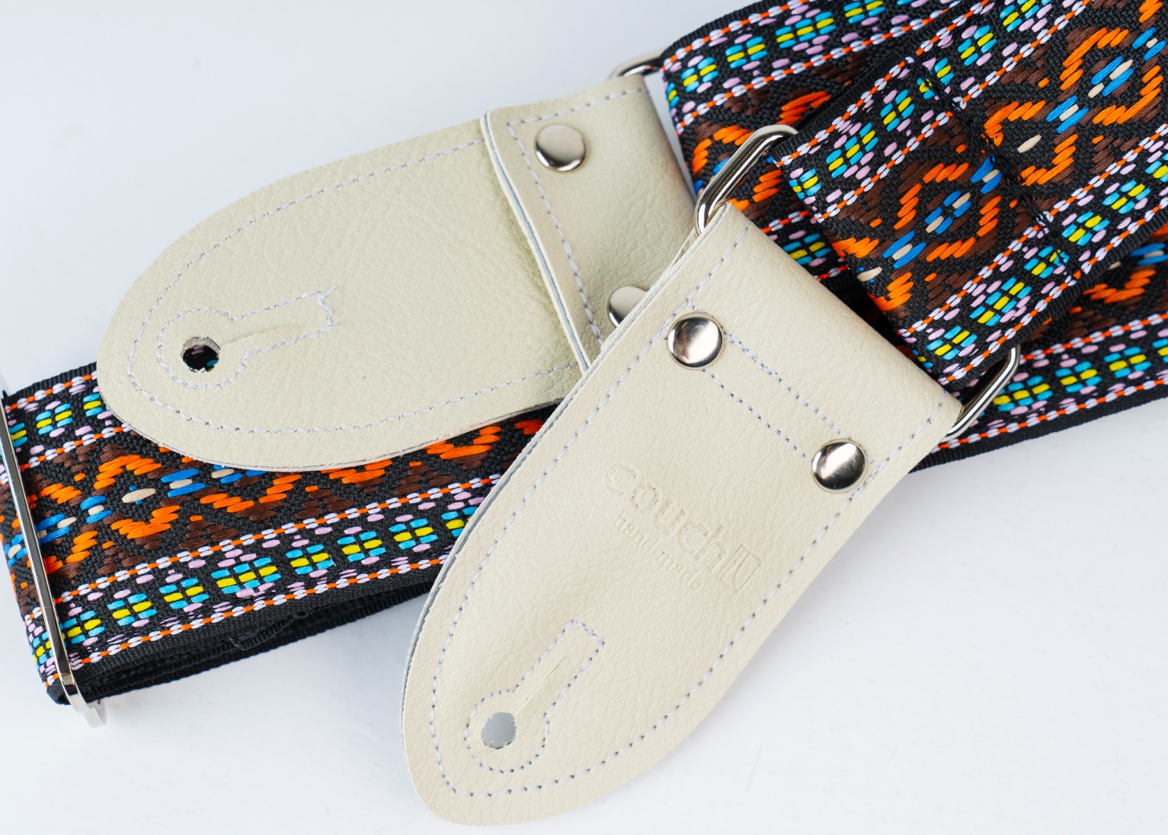 The two-rivet white vinyl end tab with heat-stamped Couch logo on the Turquoise Desert strap