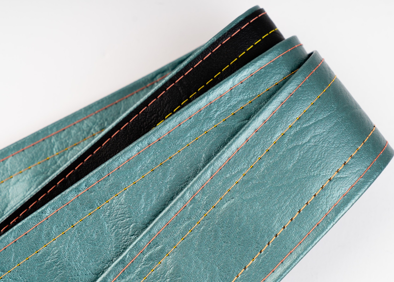 Close-up of the rose and orange luggage stitching on the Selenium strap
