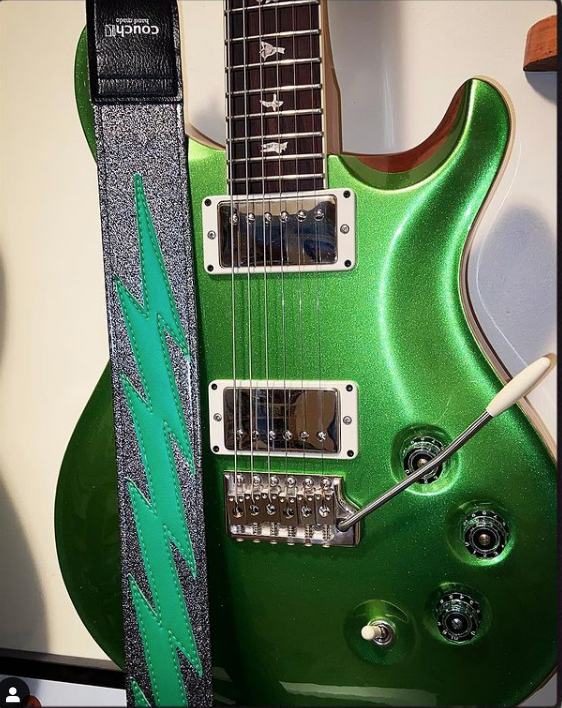 Silver sparkle strap with a green bolt, color-matched to a green metallic guitar