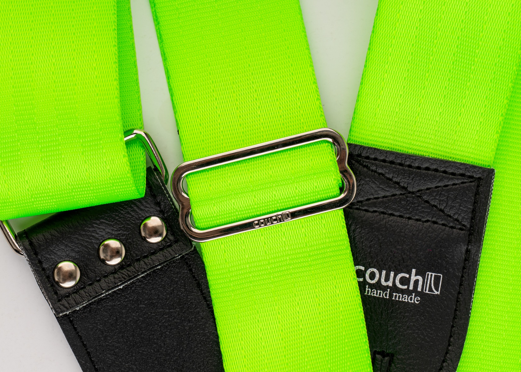 Close-up of the logo-stamped steel slide adjuster on the neon green strap