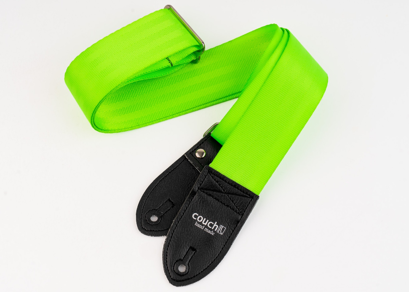 The full neon green seatbelt guitar strap coiled, showing both black vinyl end tabs