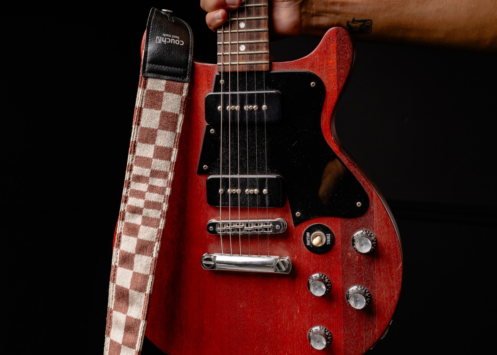 The Pasha limited edition guitar strap with a cherry electric guitar