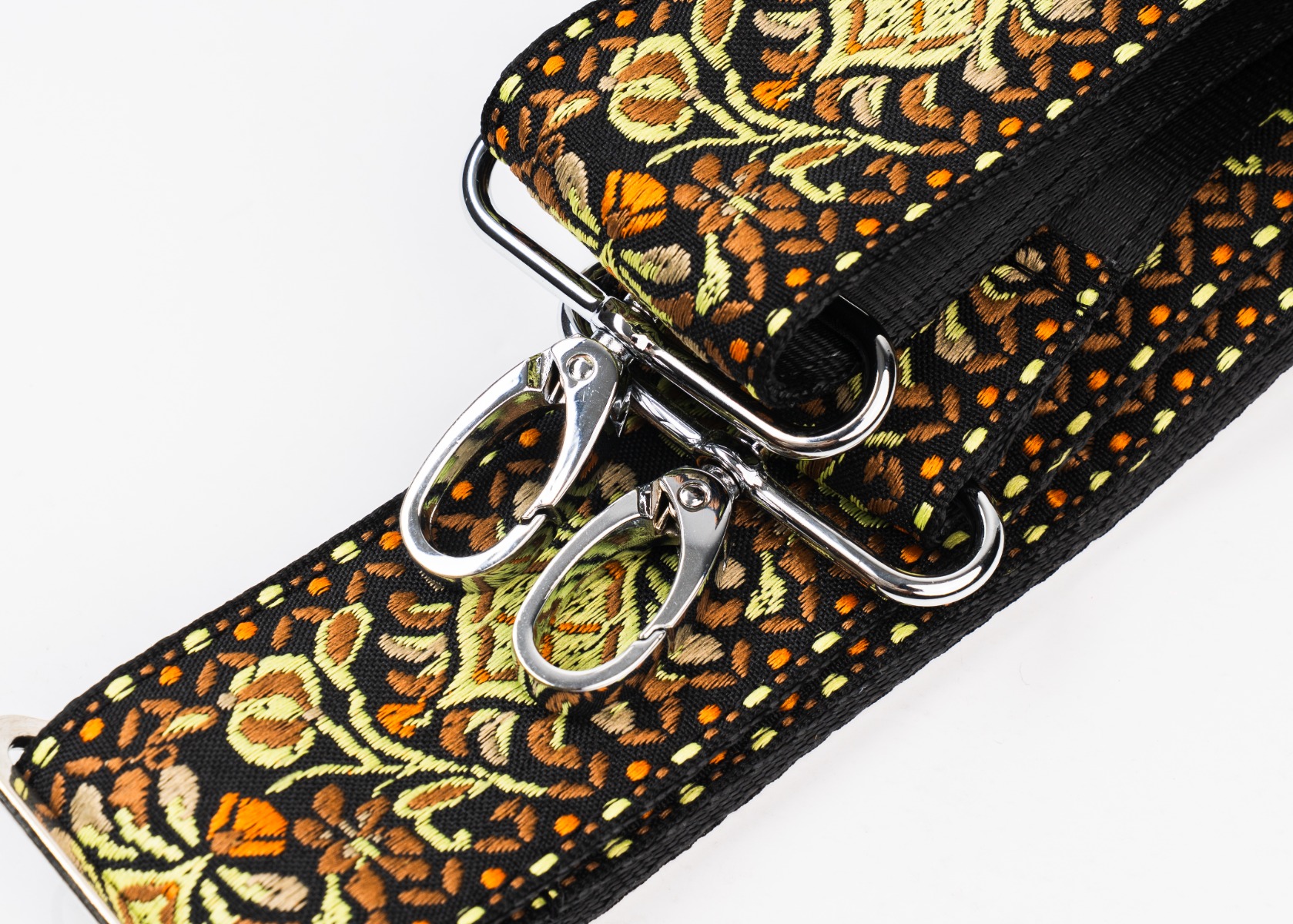 Close-up of the Psych Sunset Yellow & Gold woven purse strap and its shiny nickel swivel snap hooks
