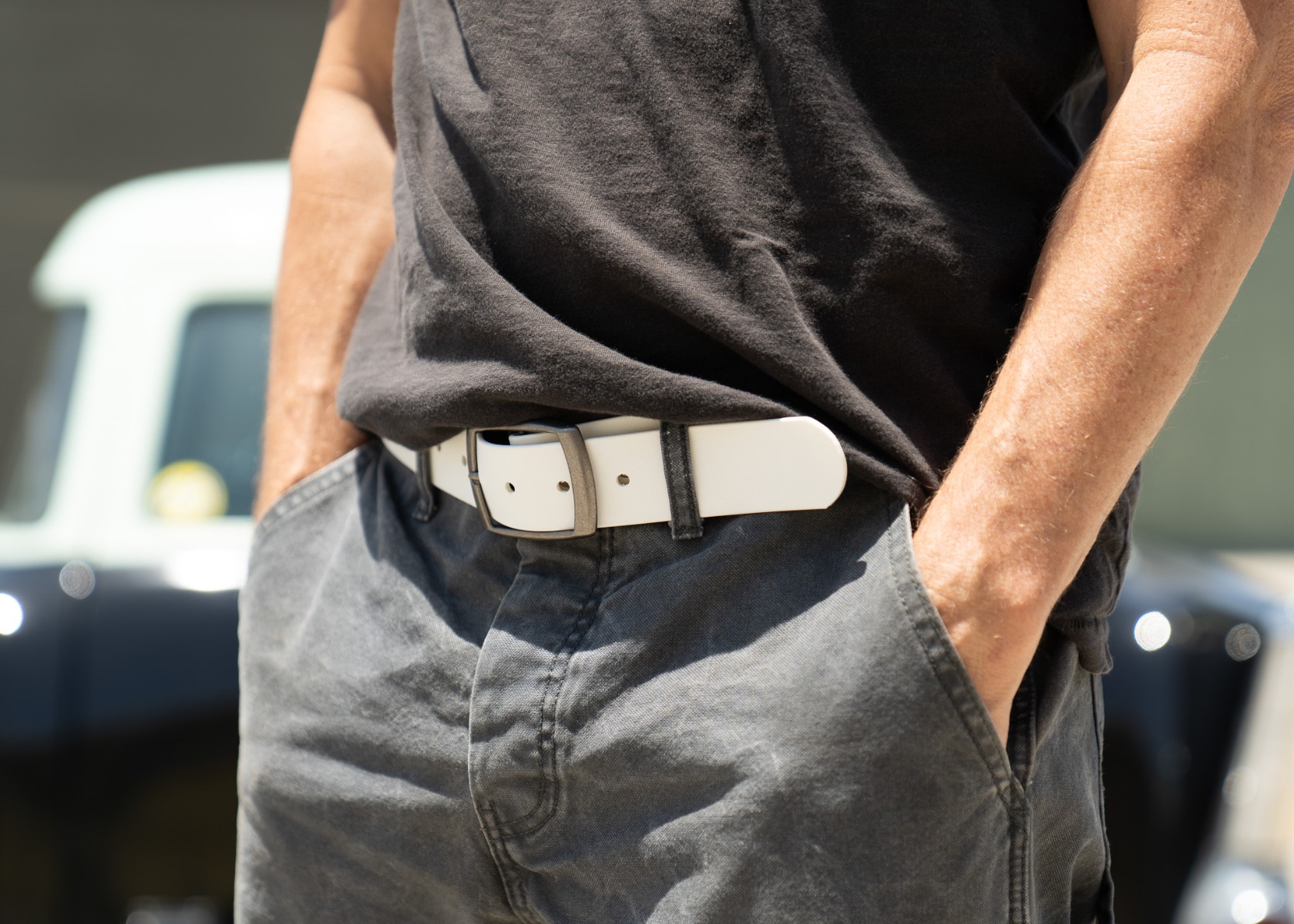 The white BioThane belt worn with dark jeans and a black tee
