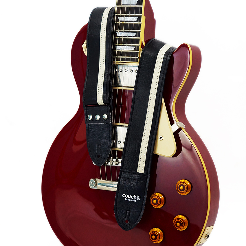 The black and white Racer X guitar strap worn on a Les Paul-style guitar