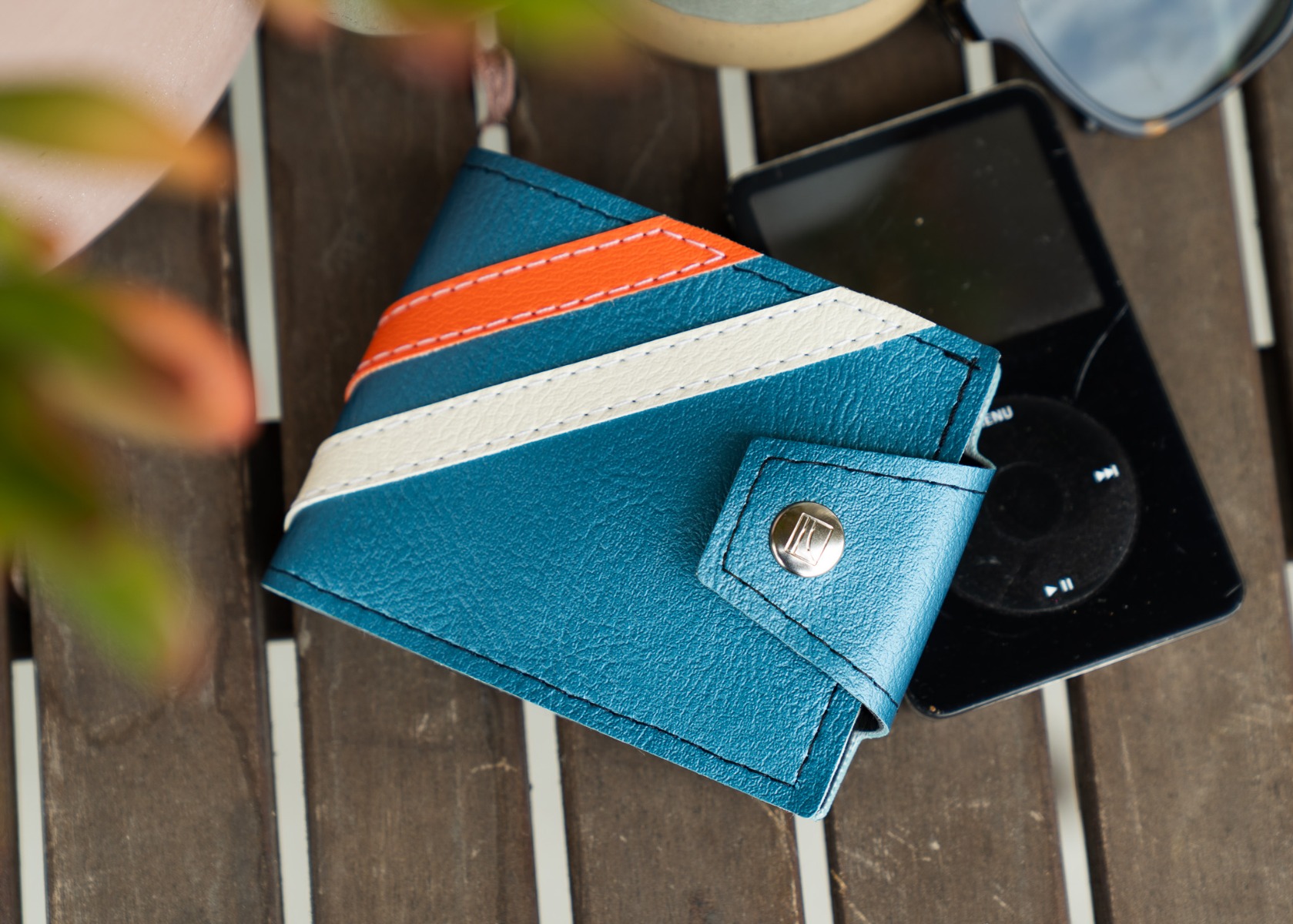 The Jet Age wallet on a table with sunglasses and an iPod