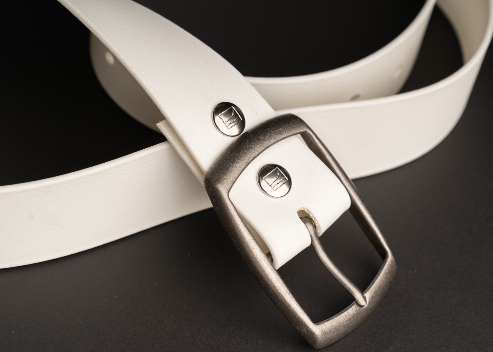 Antique silver buckle and Couch logo snaps on the white BioThane belt