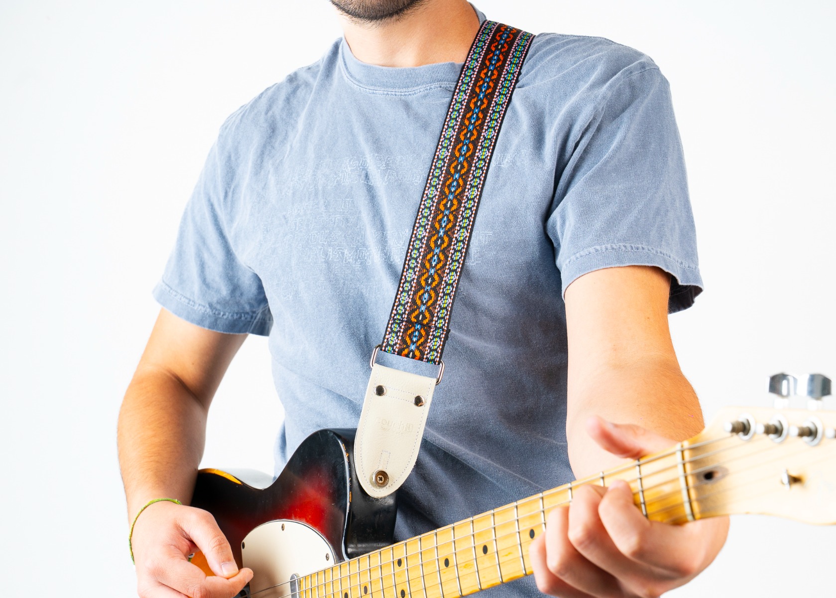 The Turquoise Desert guitar strap worn over the shoulder while playing