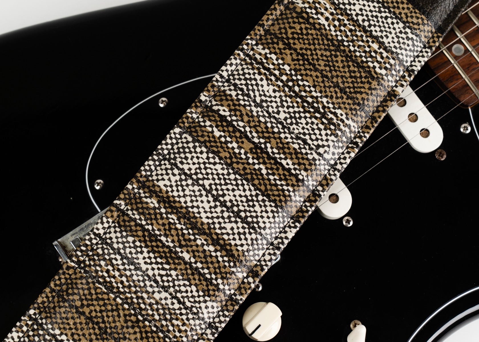 Close-up of the striped vintage auto vinyl pattern on a black guitar