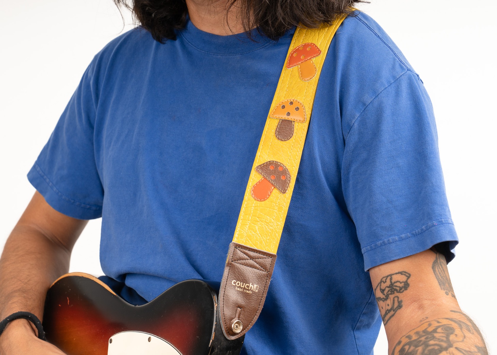 The mushroom applique guitar strap worn on the shoulder