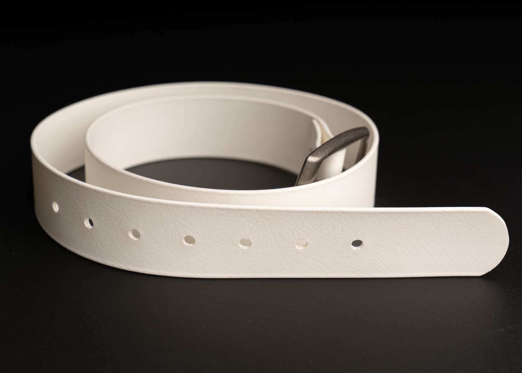 The full white BioThane belt showing its seven holes and antique silver buckle